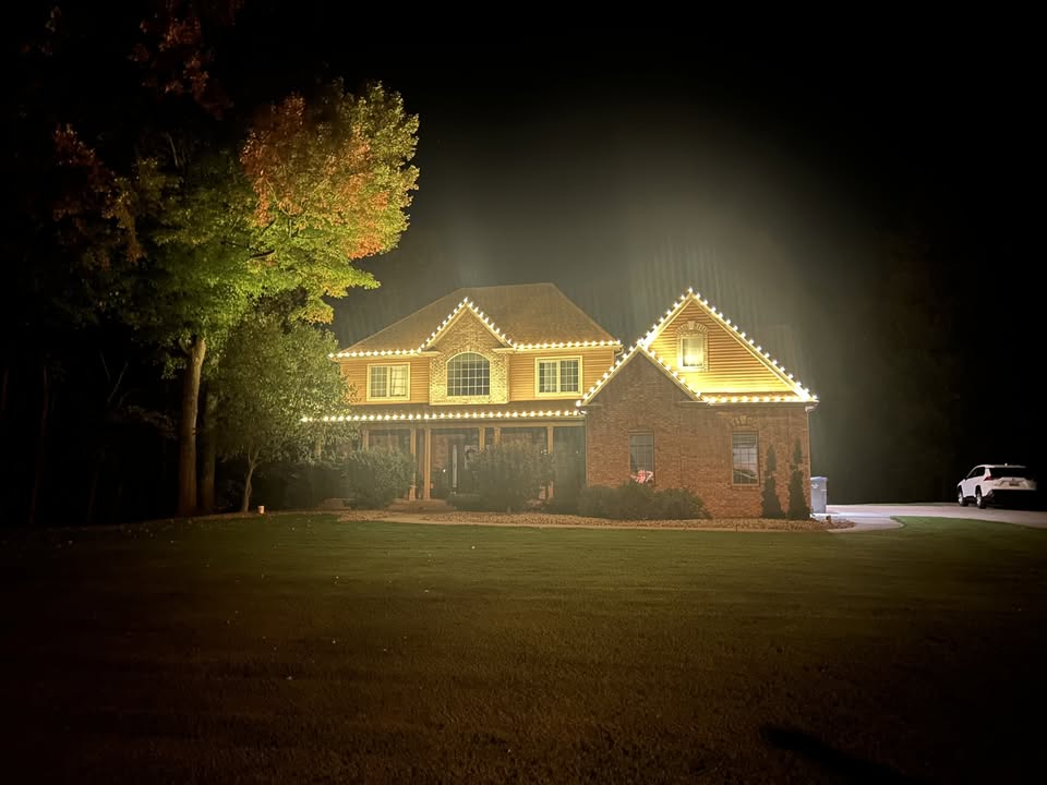 Two-story home with two peaks and warm white Christmas lights